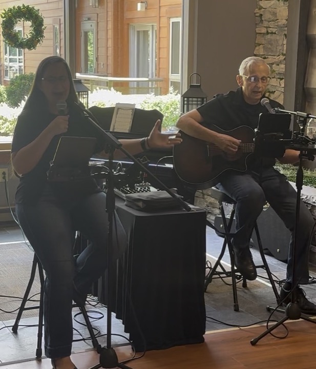 Jess and Keith performing near bright courtyard windows