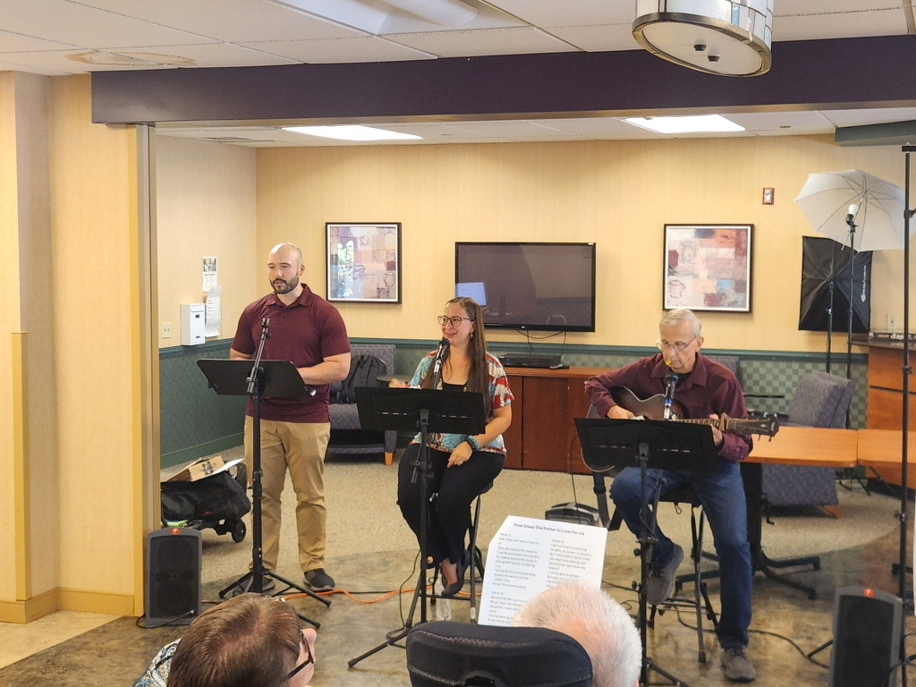 A trio with a guest musician preaching and playing